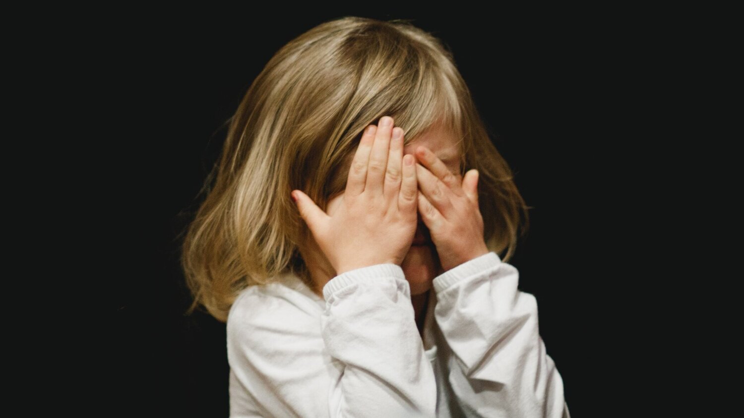 Young girl covering her eyes