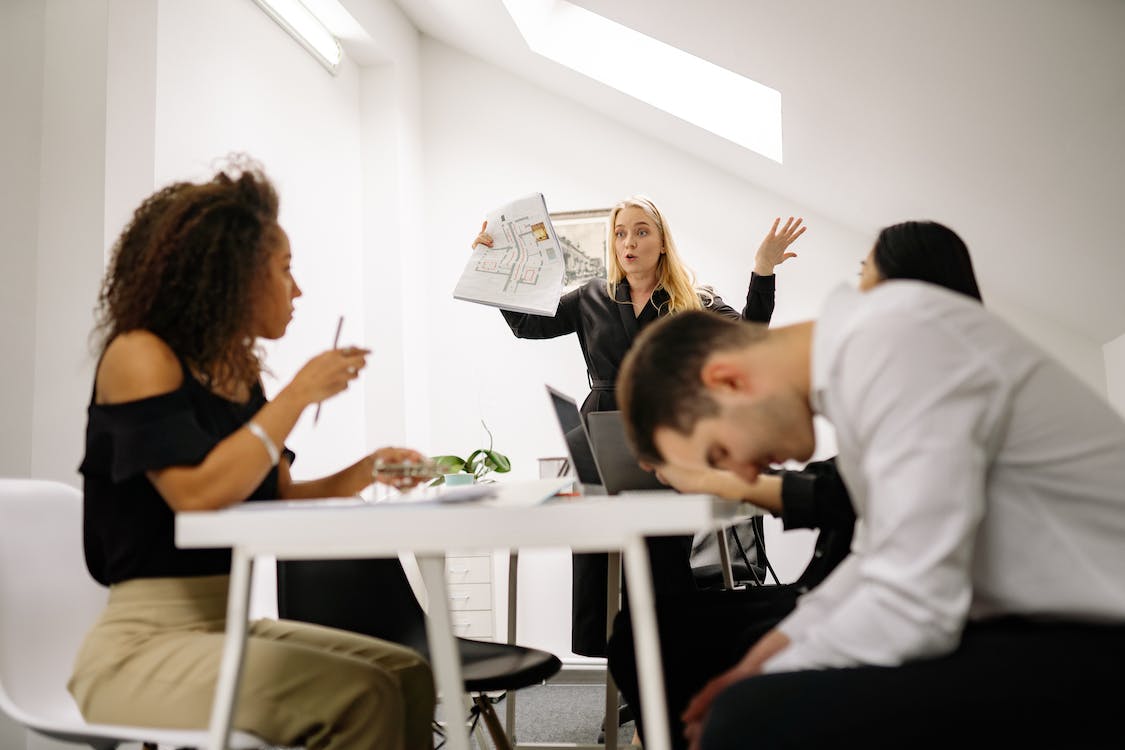 Frustrated employees gathering around a table not following the company culture